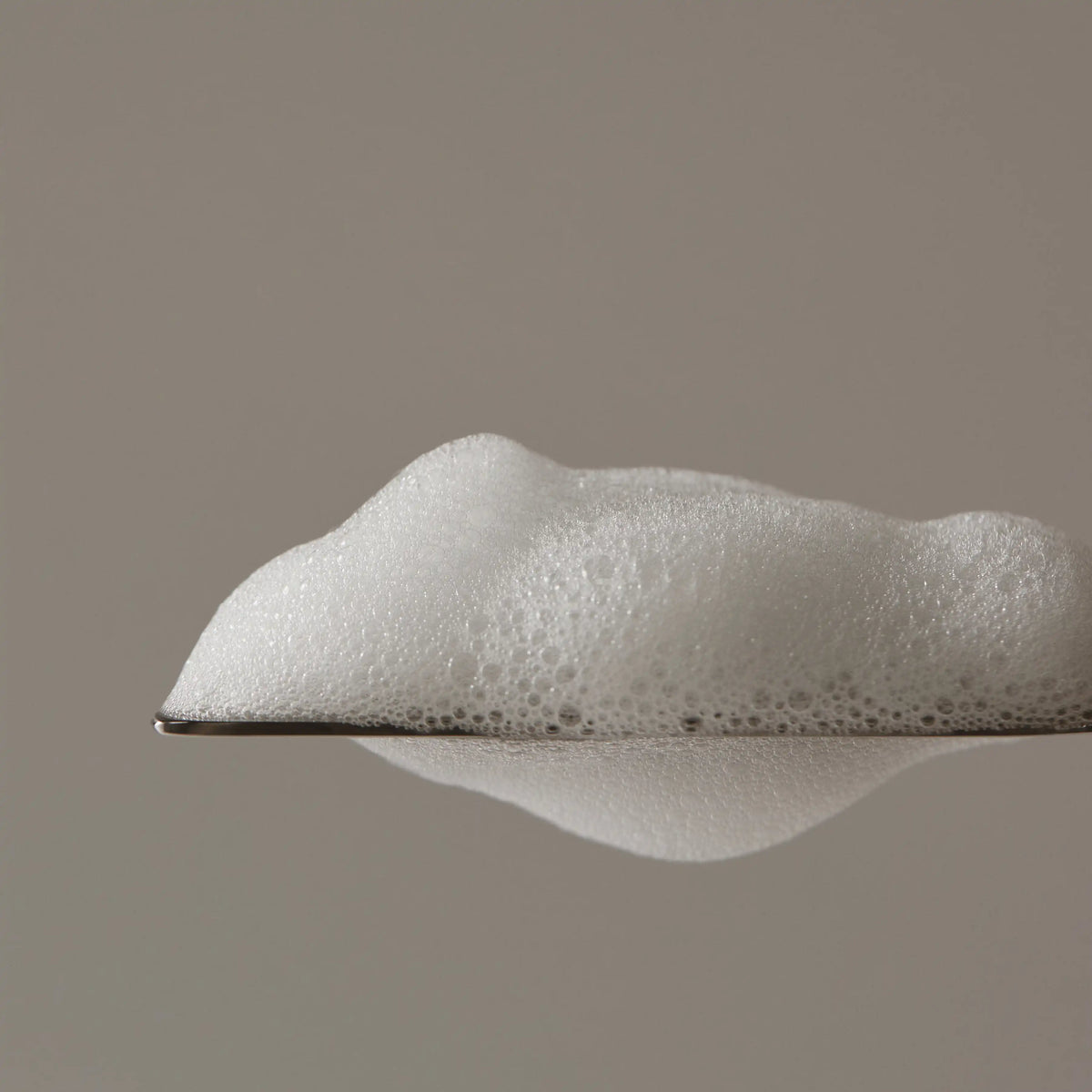 Aromatica Tea Tree Purifying Shampoo foam scooped with spatula