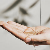 Dashu Pro Airy Polish Hair Oil being dispensed onto hand