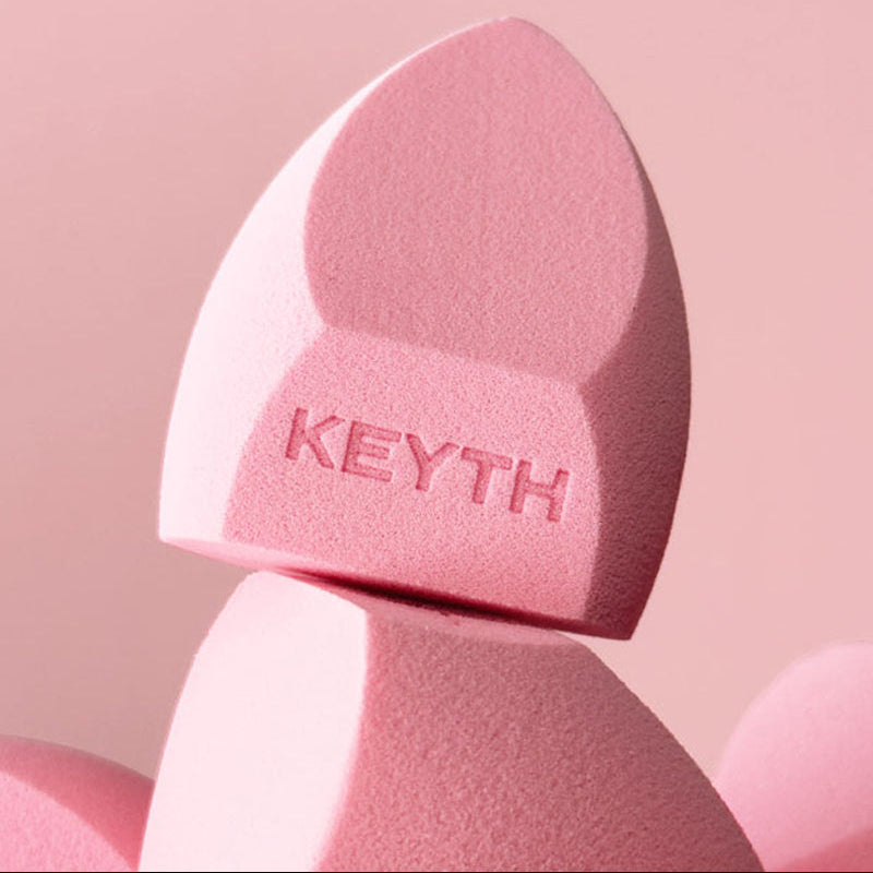 Pink makeup sponge with 'KEYTH' branding on a pink background