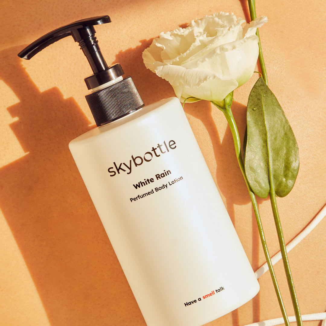 Skybottle Perfumed Body Lotion White Rain 300ml bottle with fresh flowers in background