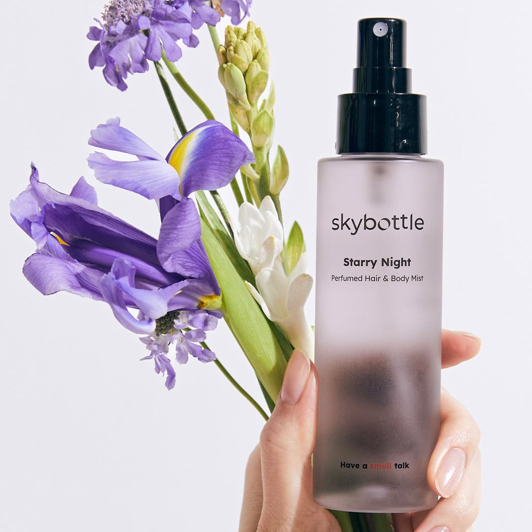Skybottle Perfumed Hair Body Mist Starry Night 100ml held in hand with flowers